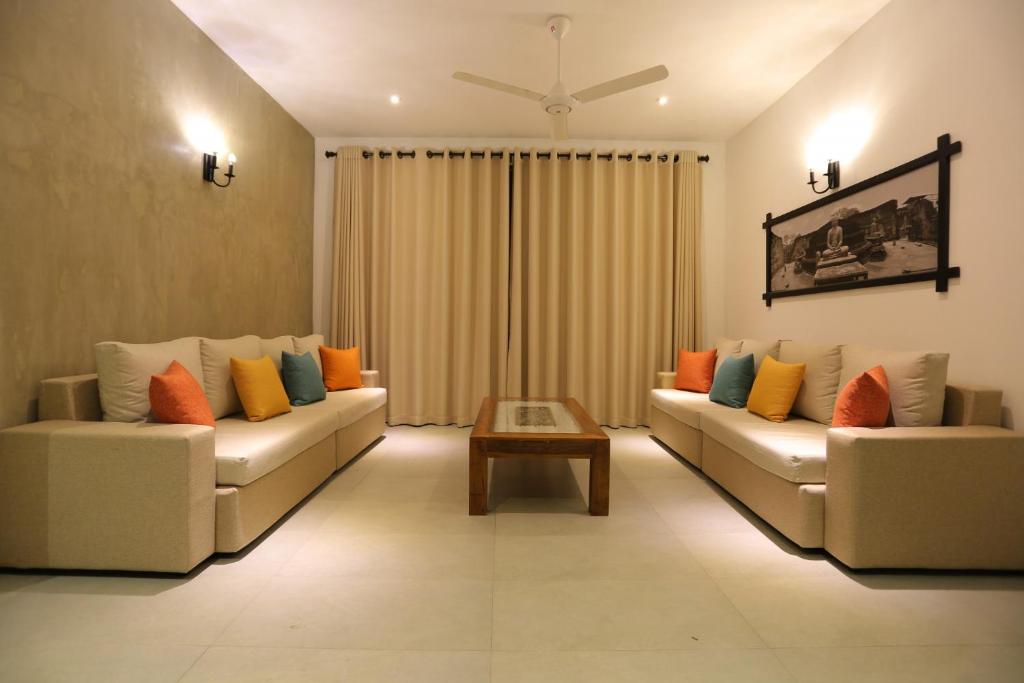 a living room with two couches and a coffee table at Lotus Lake Residence in Kandy