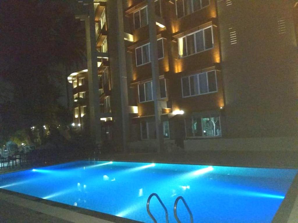 a swimming pool in front of a building at night at Sinclairs Bayview in Port Blair