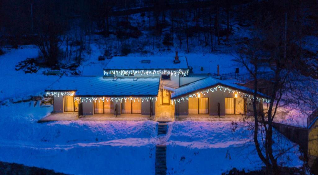une maison couverte de lumières dans la neige la nuit dans l'établissement Lo Tzeno, à Fenis
