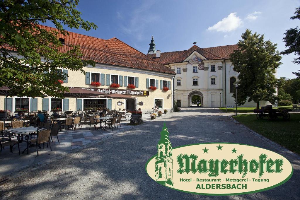 ein großes Gebäude mit einem Schild davor in der Unterkunft Hotel Mayerhofer in Aldersbach