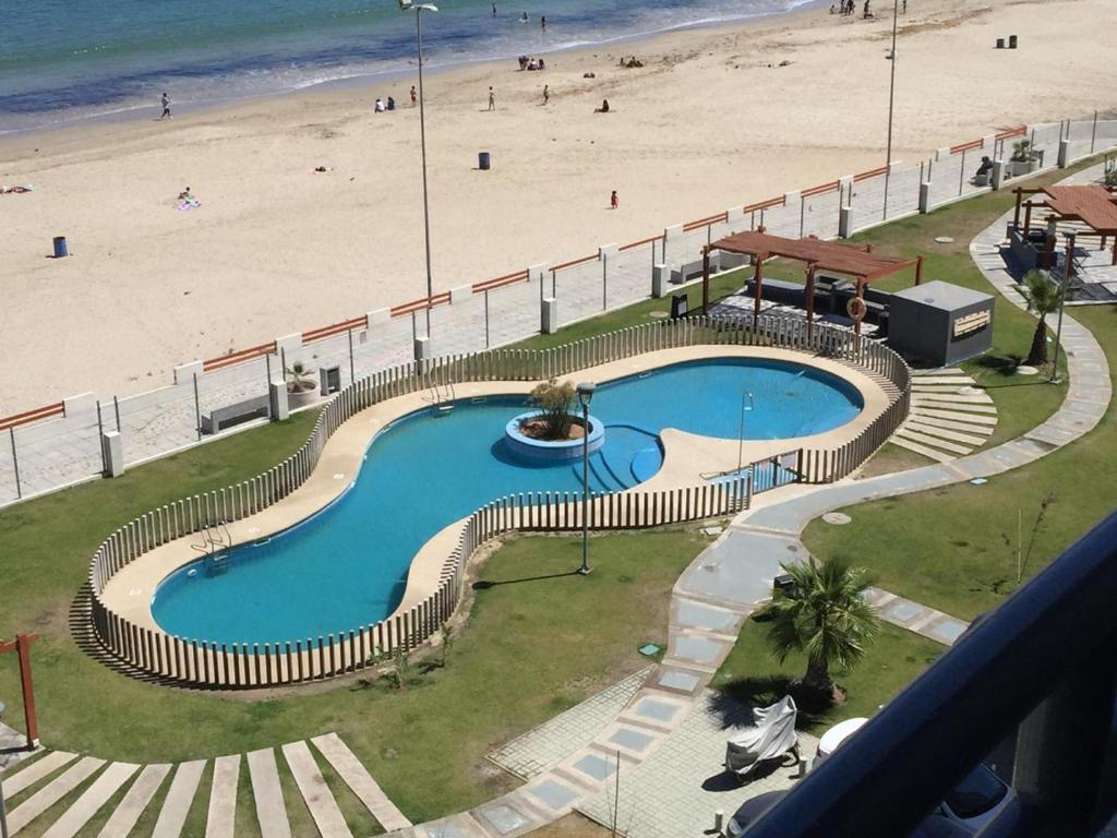 een zwembad naast een strand en de oceaan bij Apartment Joet La Herradura in Coquimbo