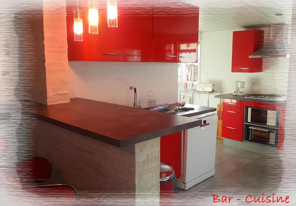 a kitchen with red cabinets and a counter top at La Maison des Oiseaux in Eu