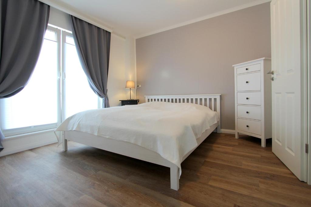 トラフェミュンデにあるPEMATRA Haus Sonnenschein - FeWo Heimathafenの白いベッドルーム(ベッド1台、窓付)