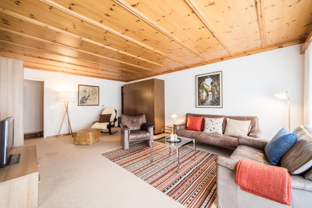 uma sala de estar com um sofá e uma mesa em LAAX Homes - Val Signina 1-13a em Laax