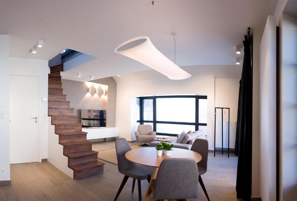 uma sala de estar com uma mesa e uma escada em Apart! & Moment! em De Haan