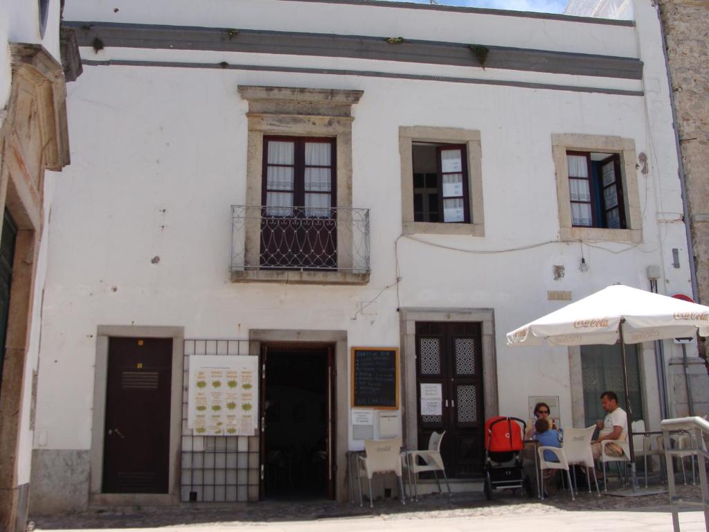 un edificio blanco con gente sentada en mesas delante de él en Aguarela Tavira, en Tavira