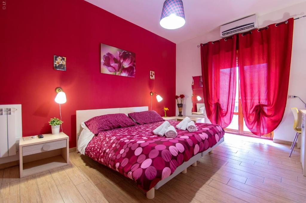 una camera da letto con pareti rosse e un letto con lenzuola viola di B & B San Cataldo a San Cataldo