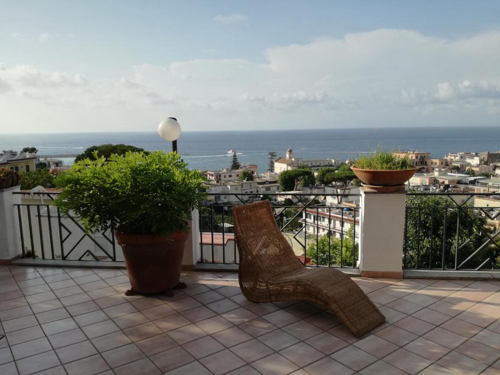 a balcony with two chairs and a view of the ocean at "CASA SUNSET" in Ischia