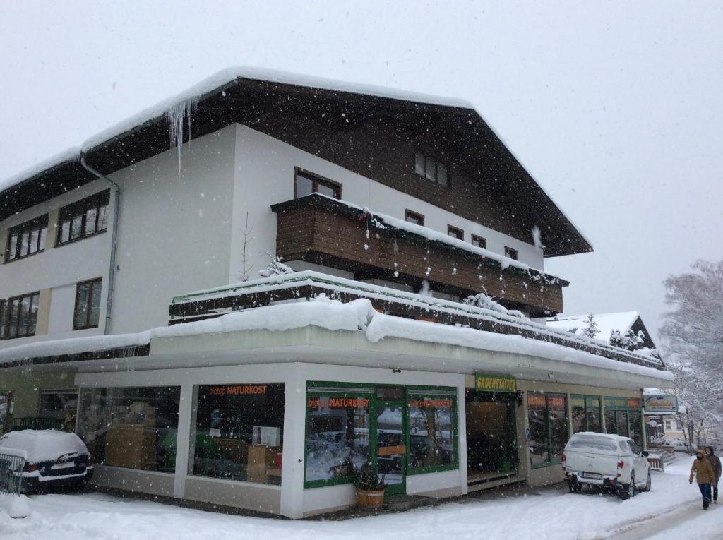 a building with snow on the top of it at Gadenstätter Apartments in der City in Zell am See
