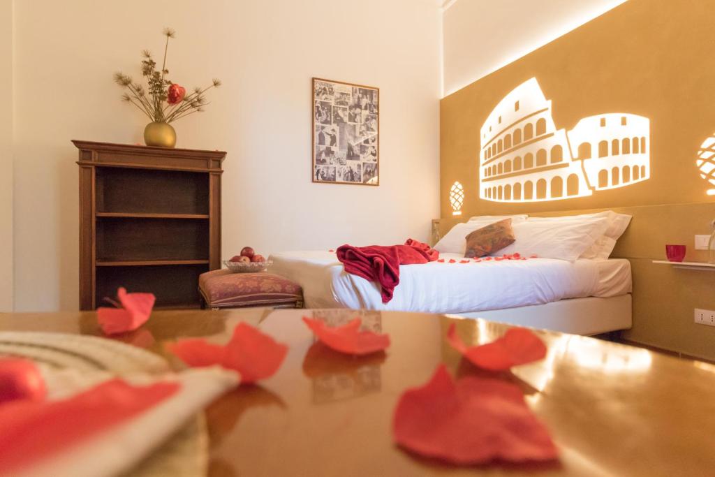 - une chambre avec un lit et une table ornée de fleurs rouges dans l'établissement A Star Inn, à Rome