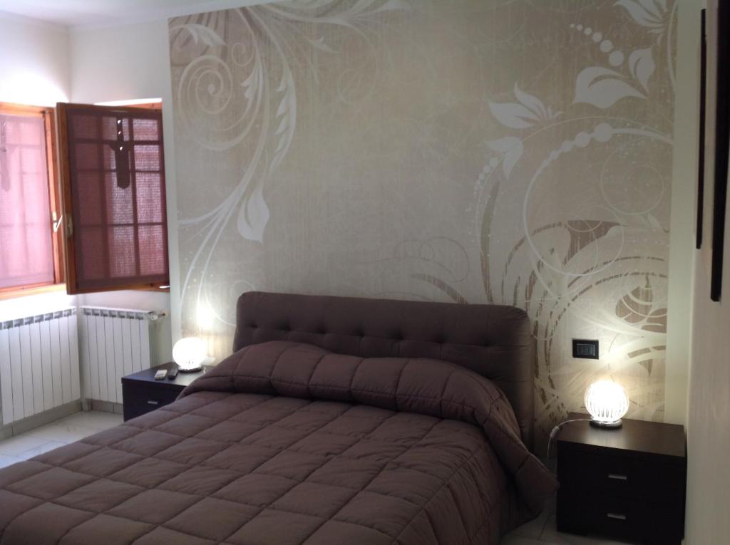 una camera con letto e parete con murale floreale di La stanza di villa Sara a Civitavecchia