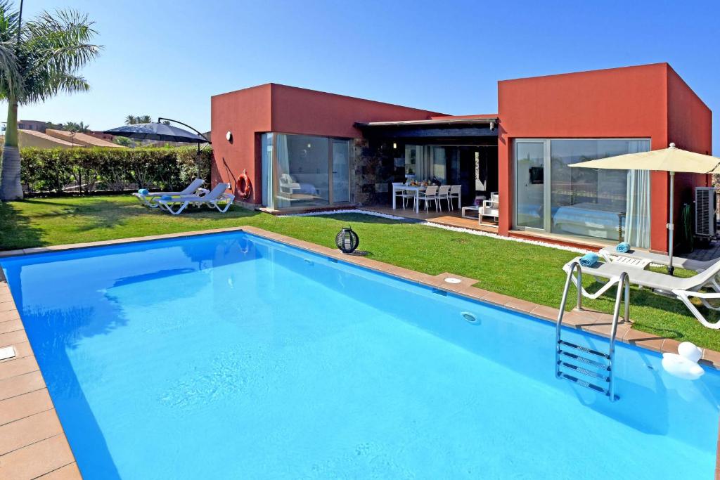 una gran piscina frente a una casa en Salobre Par 4 Nº4, en Maspalomas