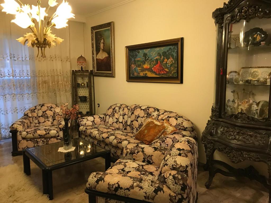 ein Wohnzimmer mit einem Sofa und einem Tisch in der Unterkunft Luxury apartment close to city center, university and children's hospital in Athen