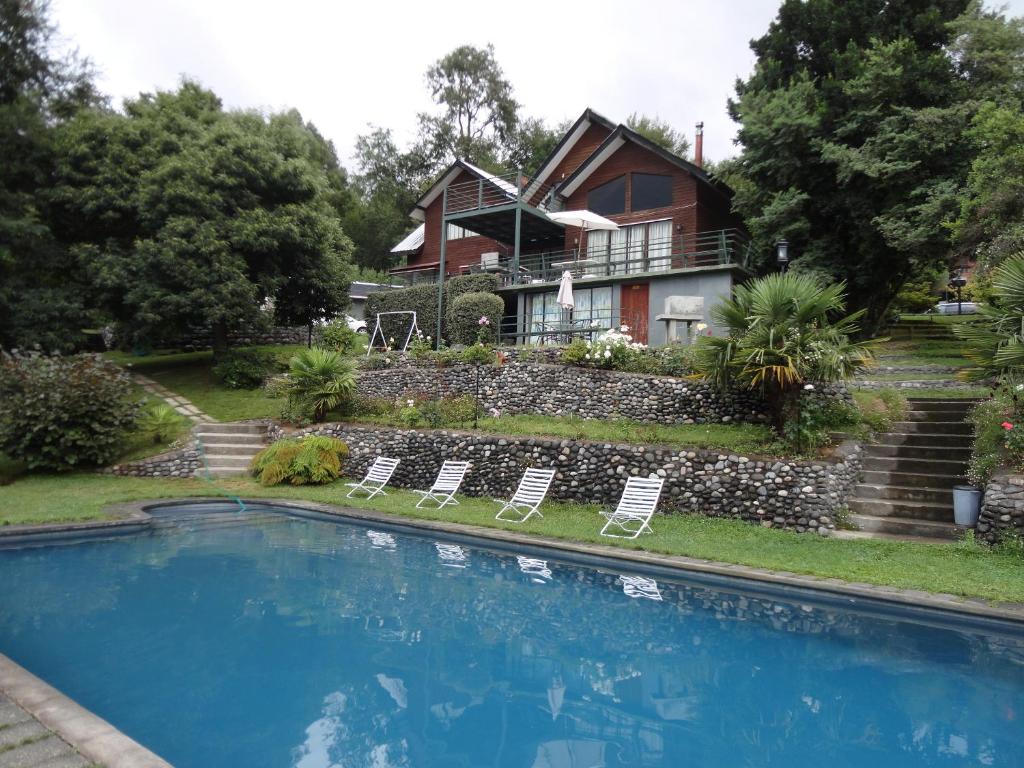 una casa con piscina frente a una casa en Complejo Turístico Pucón, en Pucón