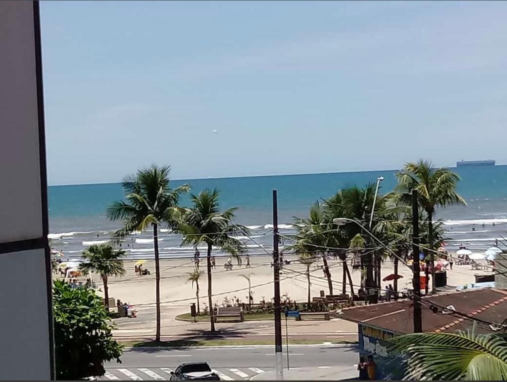 a view of a beach with palm trees and the ocean at Ed.Valéria IIPraia Grande in Praia Grande