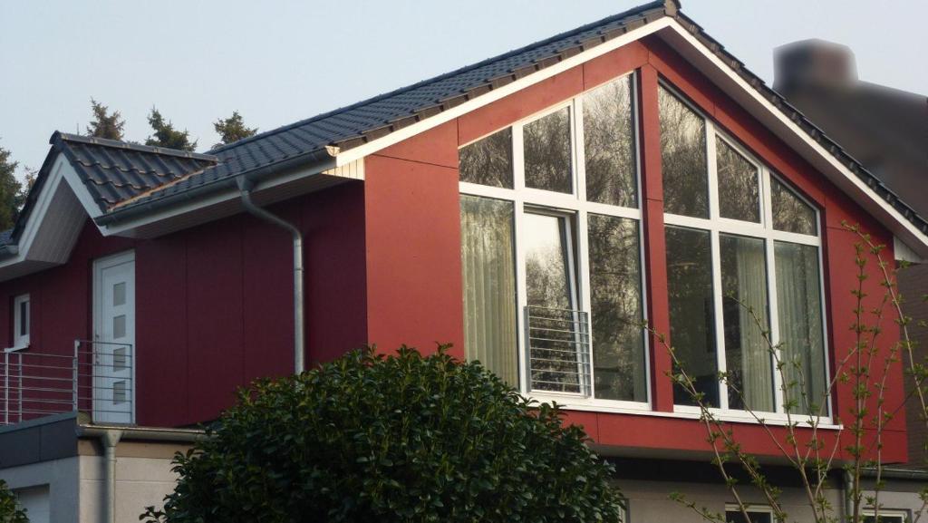 ein rotes Haus mit weißen Fenstern darauf in der Unterkunft Fewo Ausblick in Hechthausen