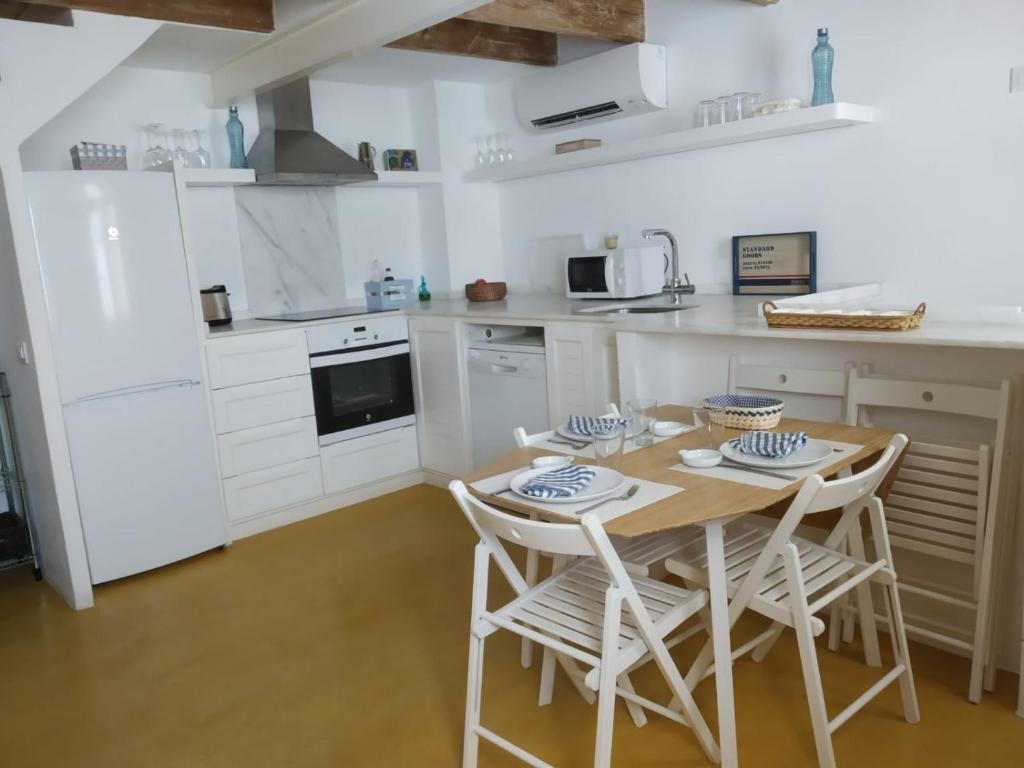 a kitchen with a wooden table and chairs in it at Andrones in Ciutadella