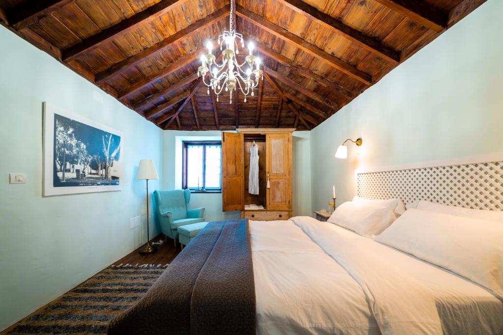 a bedroom with a large bed and a chandelier at Casa Azul in Fuencaliente de la Palma