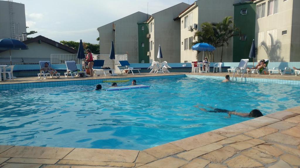 um grupo de pessoas a nadar numa piscina em APTO ESPETACULAR a 50 m do Mar em Condomínio com PISCINAS MARAVILHOSAS em Brejatuba