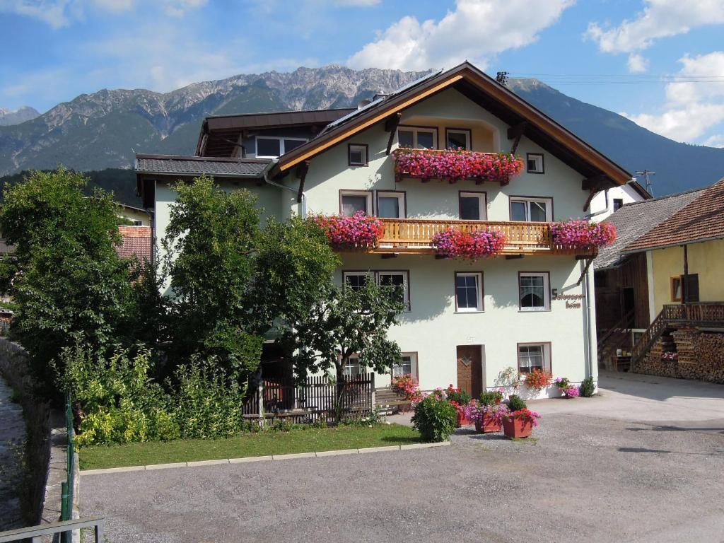 ein großes weißes Gebäude mit Blumen darauf in der Unterkunft Salvesenheim in Tarrenz