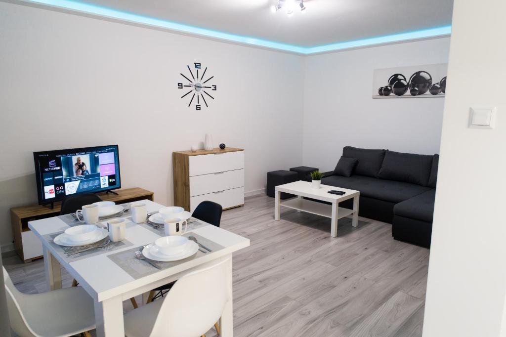 a living room with a white table and a couch at APARTAMENT FOCUS in Gdynia