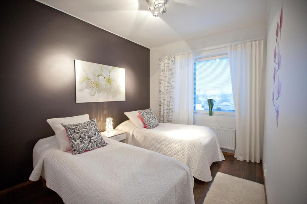 a room with two beds and a window at Joutsen Apartments in Rovaniemi