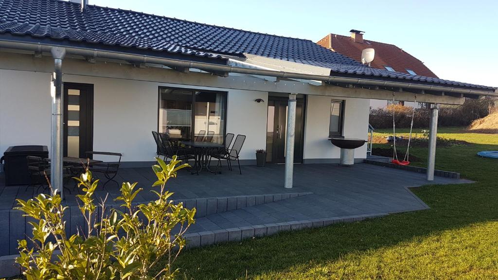 a house with a deck with a table and chairs at Ferienwohnung FERRUM in Korbach