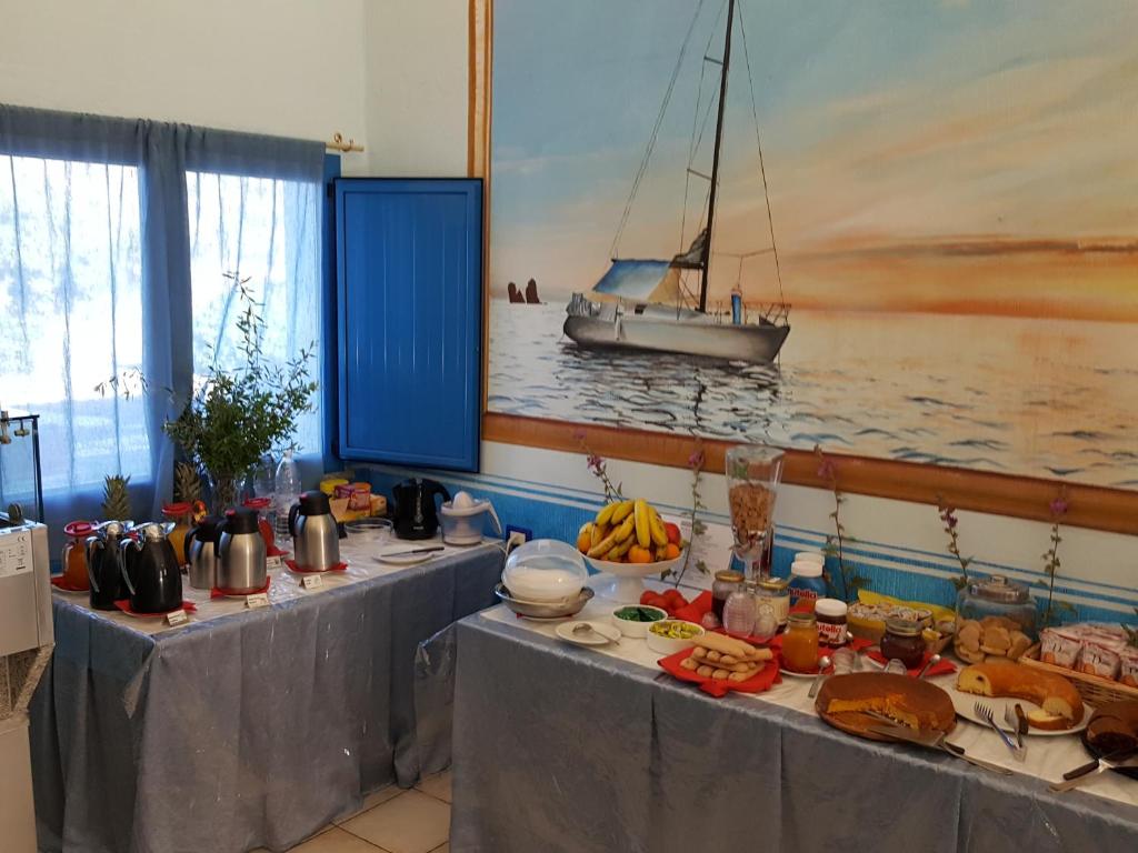a table with food and a boat in a room at Hotel Baia Cea in Bari Sardo
