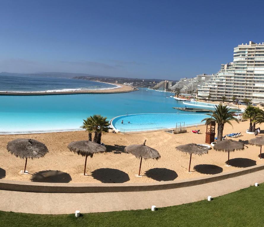 - Vistas a la piscina con sombrillas y a la playa en Precioso San Alfonso del Mar, en Algarrobo