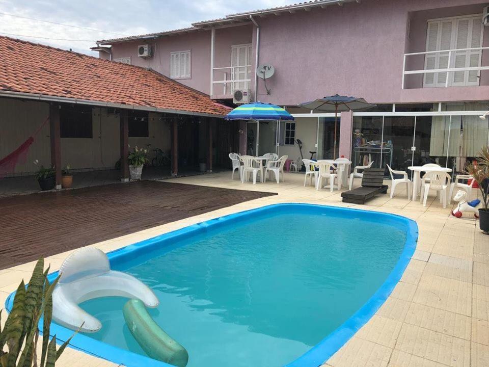 una gran piscina azul frente a una casa en Casa Ingleses, en Florianópolis