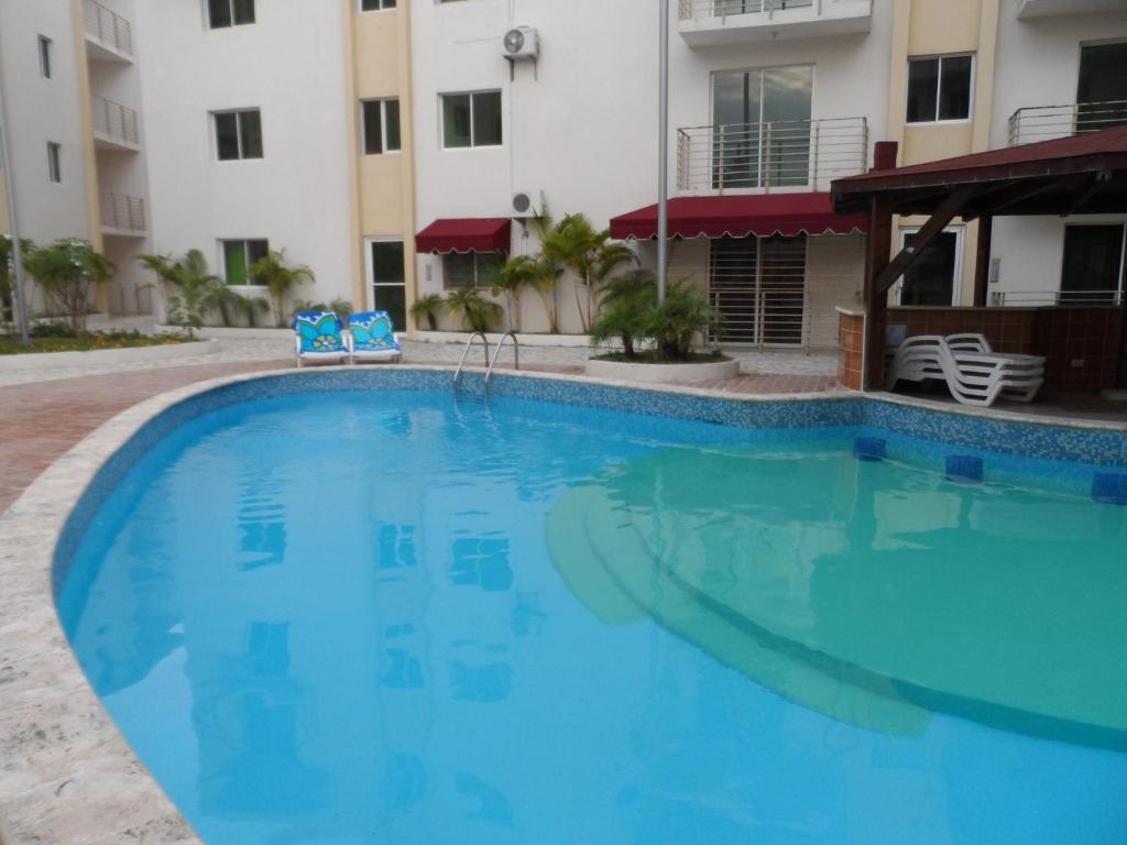 a large swimming pool in front of a building at Apartamento Aquarel in Boca Chica