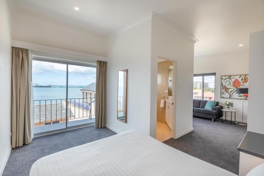 a bedroom with a bed and a view of the ocean at Bay 10 - Suites and Apartments in Port Lincoln