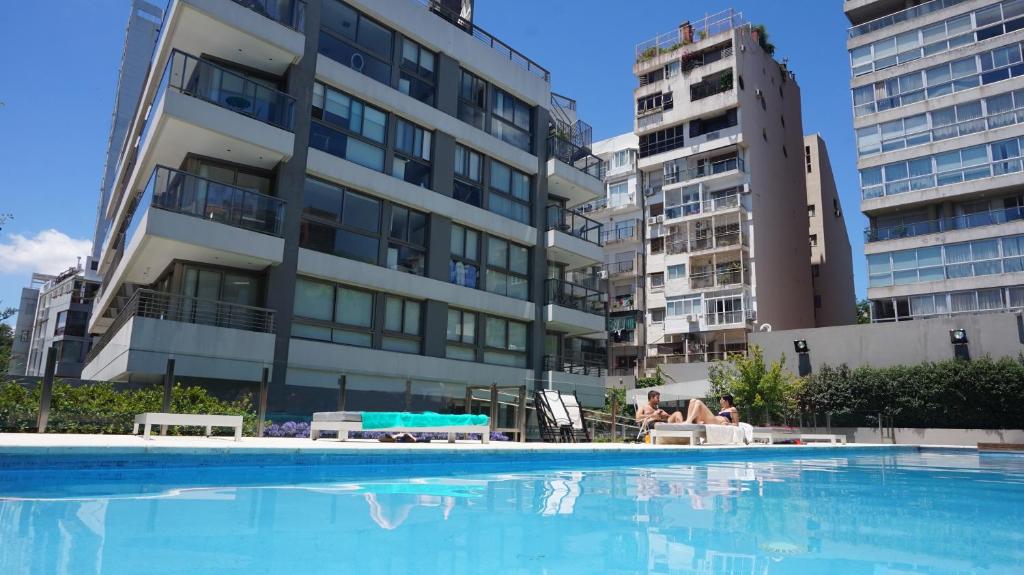 une grande piscine en face d'un bâtiment dans l'établissement Privilege Studios in Terrazas Polo, à Buenos Aires