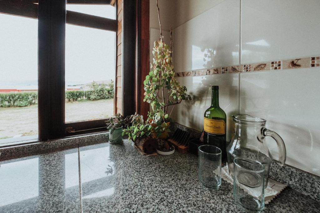 a counter with a bottle of wine and a window at Patagonia Suites in El Calafate