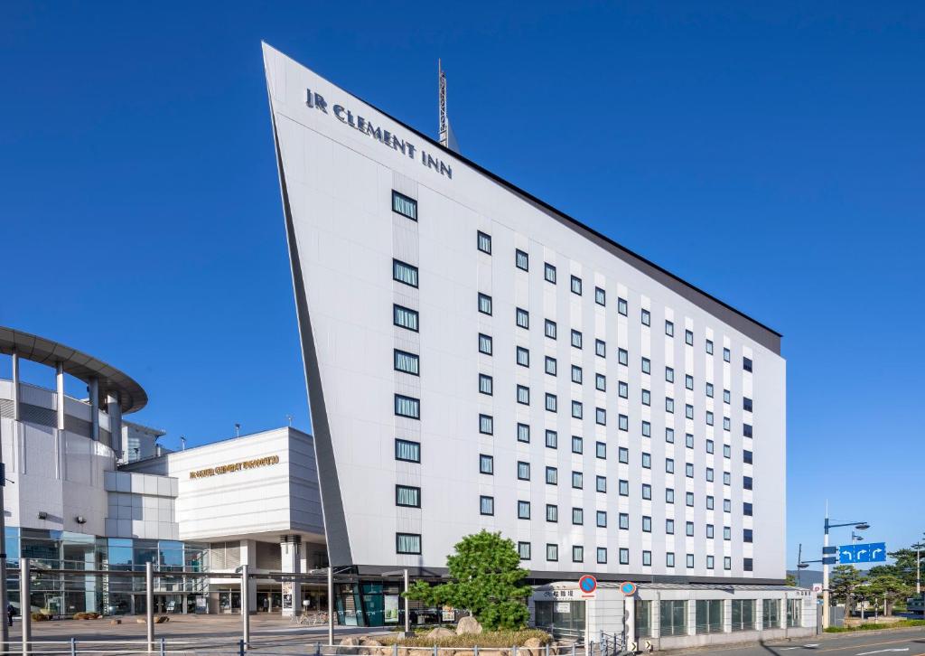 um grande edifício branco com um cartaz em JR Clement Inn Takamatsu em Takamatsu