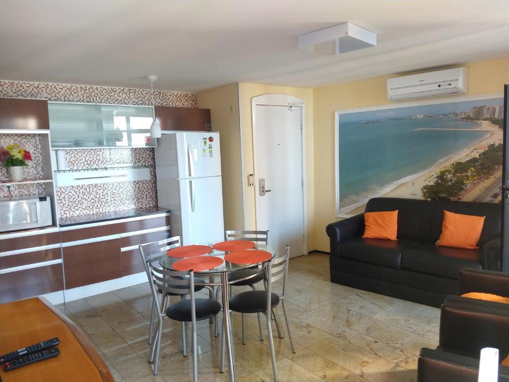 cocina y sala de estar con mesa y sofá en Flat Mar Brasil Tropical - Apartamento de 2 Quartos com Suite e Vista do Mar, en Fortaleza