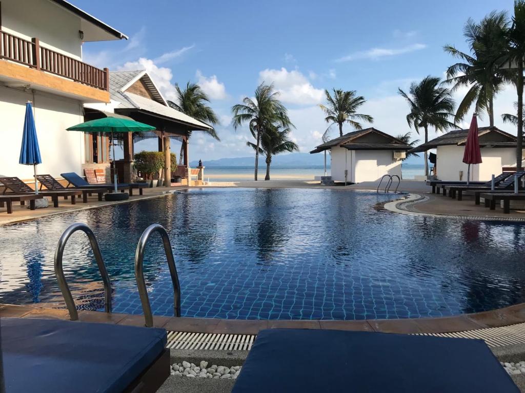 a resort swimming pool with a beach in the background at Mac's Bay Resort in Ban Tai