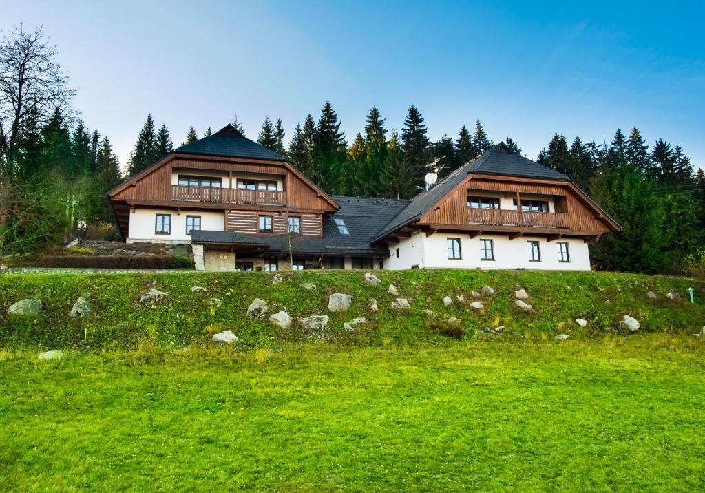 uma casa grande no topo de um campo verde em Chalupa K. Neumannove em Stachy