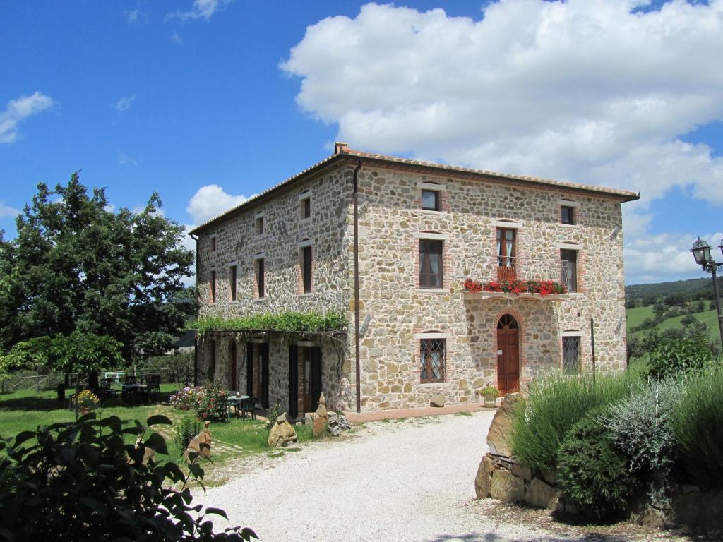 a large stone building with flowers on it at Agriturismo D' Epoca La Marianella in Catabbio