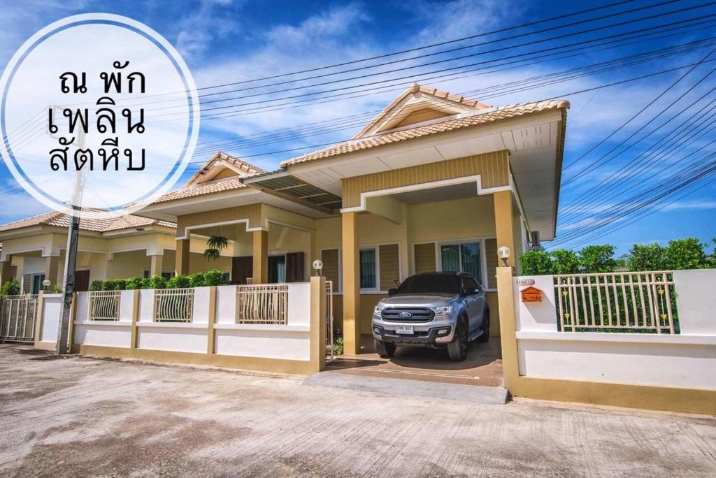 una casa con un coche aparcado delante de ella en ณ พักเพลิน @สัตหีบ en Sattahip