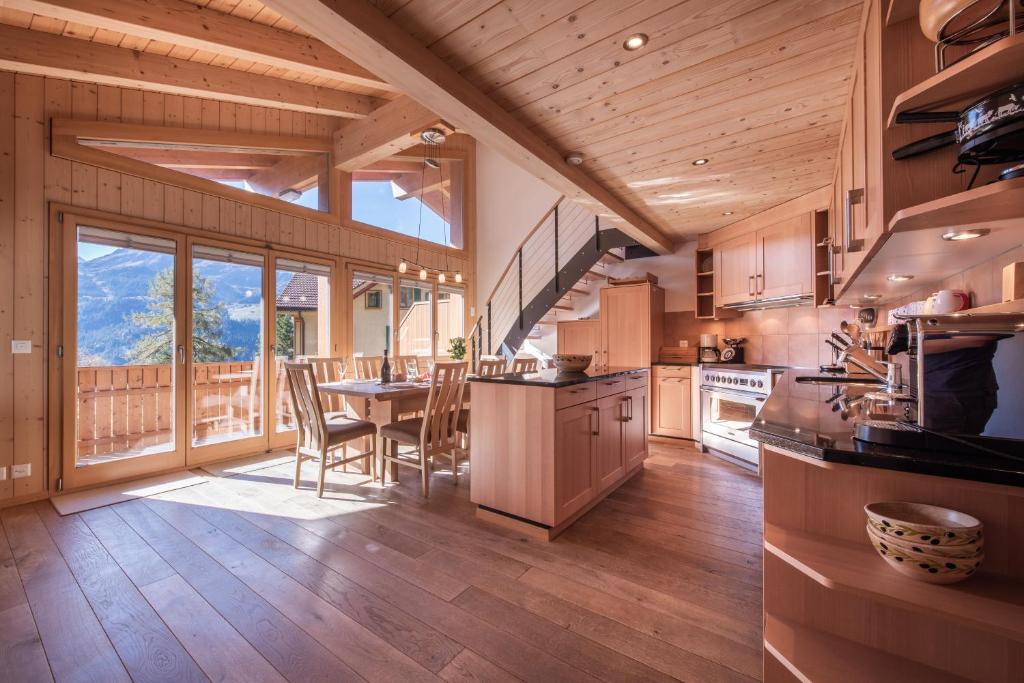 a large kitchen with a table and a large window at Chalet Aquila 8 Penthouse in Wengen