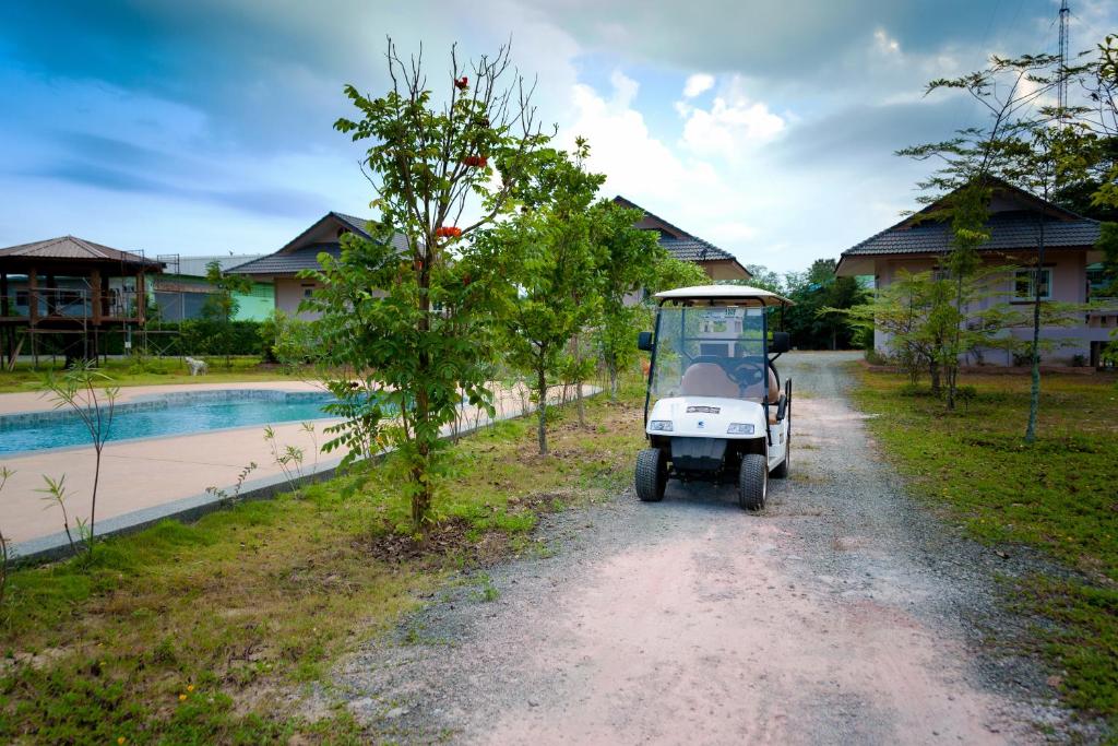 een klein voertuig geparkeerd op een onverharde weg naast een huis bij Mae Faek Villas in San Sai