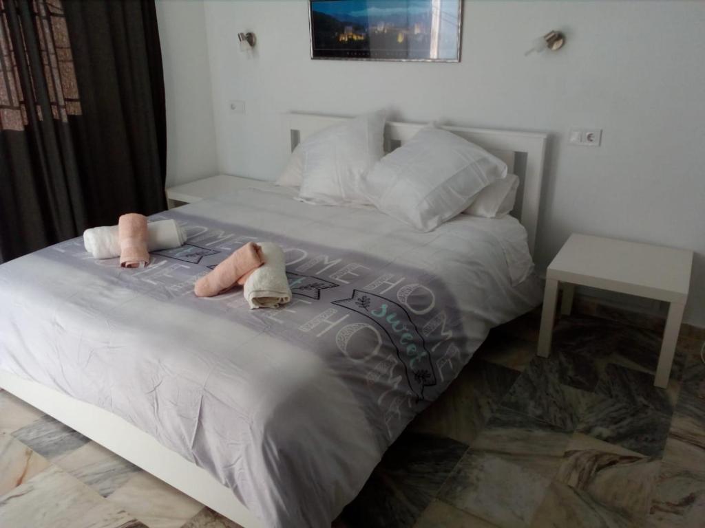 a bedroom with a bed with two stuffed animals on it at Casa Sevilla in Valencina de la Concepción