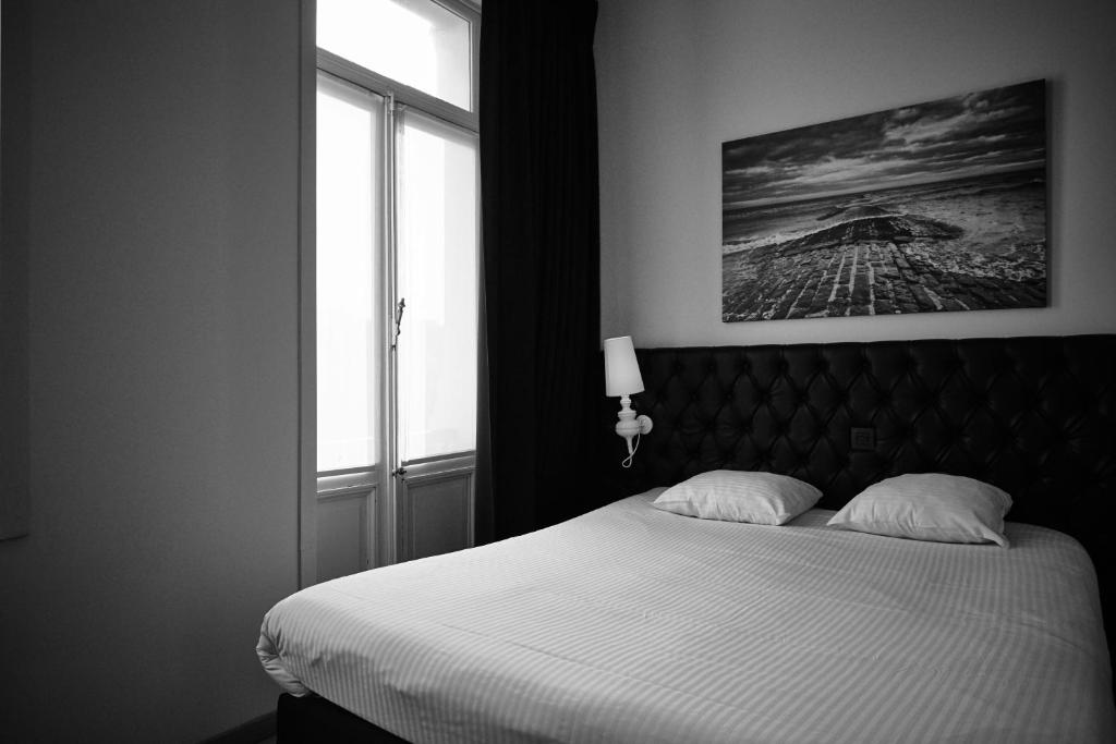 Rúm í herbergi á Hotel Le Parisien