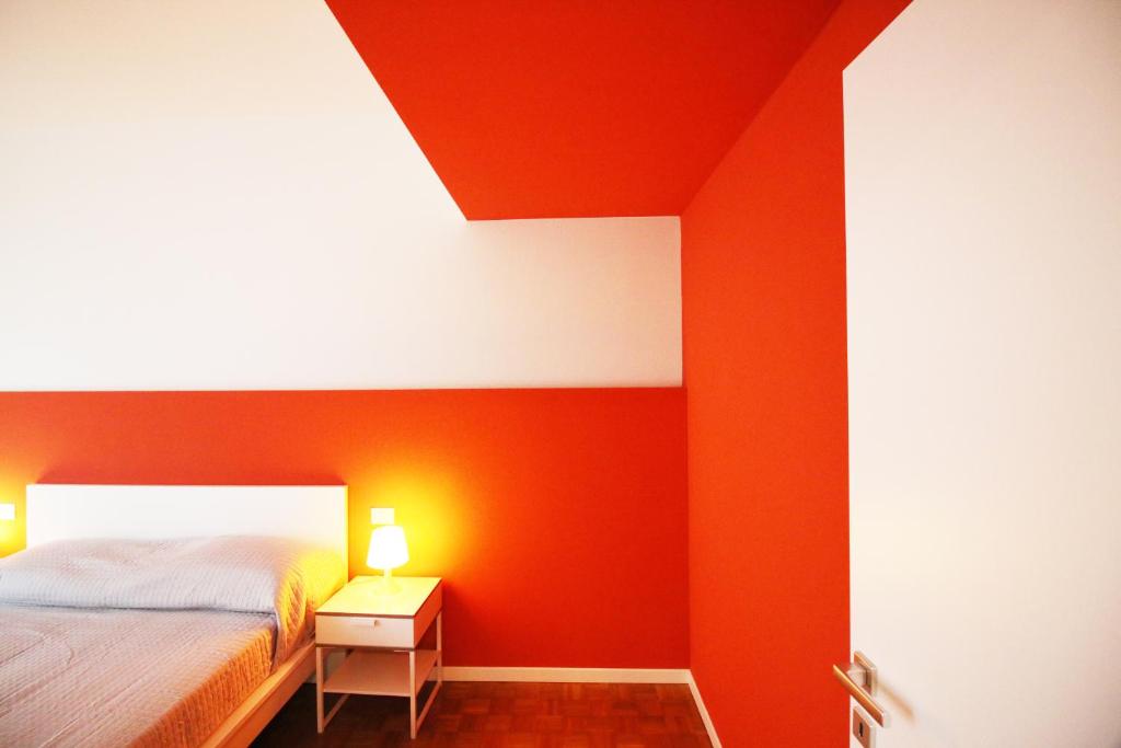 una camera da letto con una parete con accento arancione e un letto di Myresidenceverona a Verona