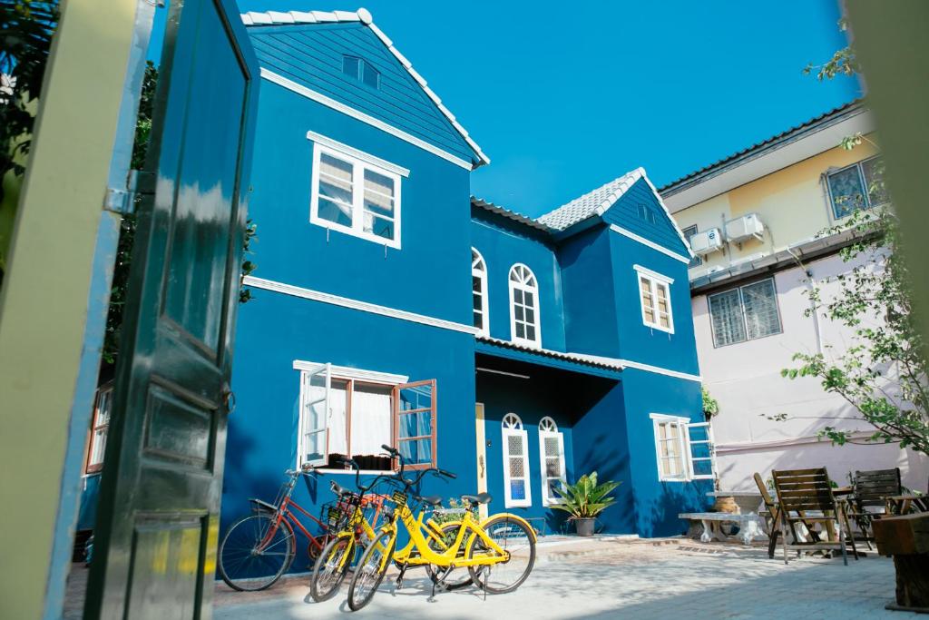 un edificio azul con bicicletas estacionadas fuera de él en Eden Hotel Bangsean, en Ban Laem Thaen