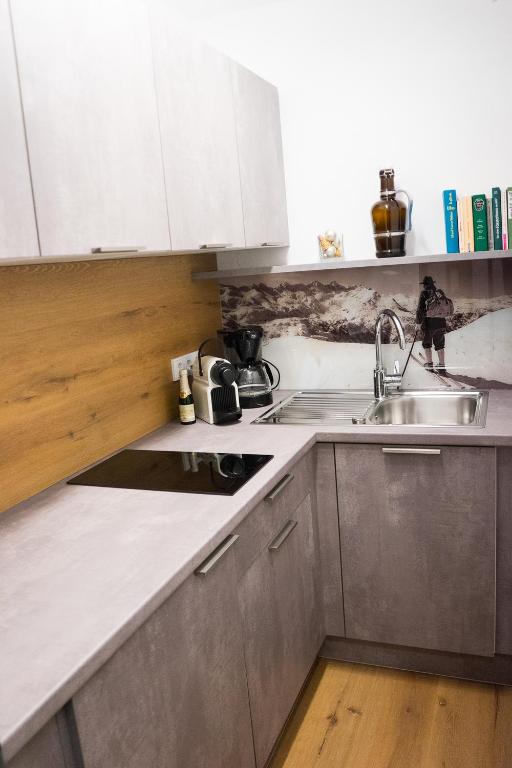 a kitchen with white cabinets and a sink at Am Wasserfall 31 in Bad Gastein