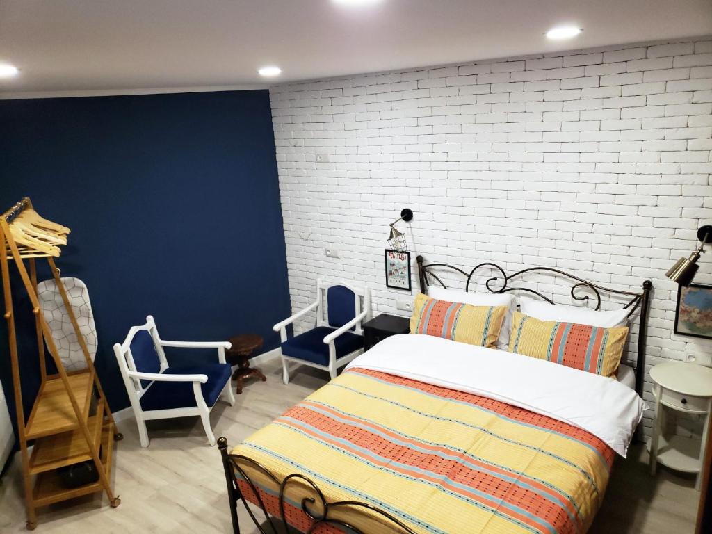 una camera da letto con un letto e sedie e un muro di mattoni di Lucky Apartment a Tbilisi City