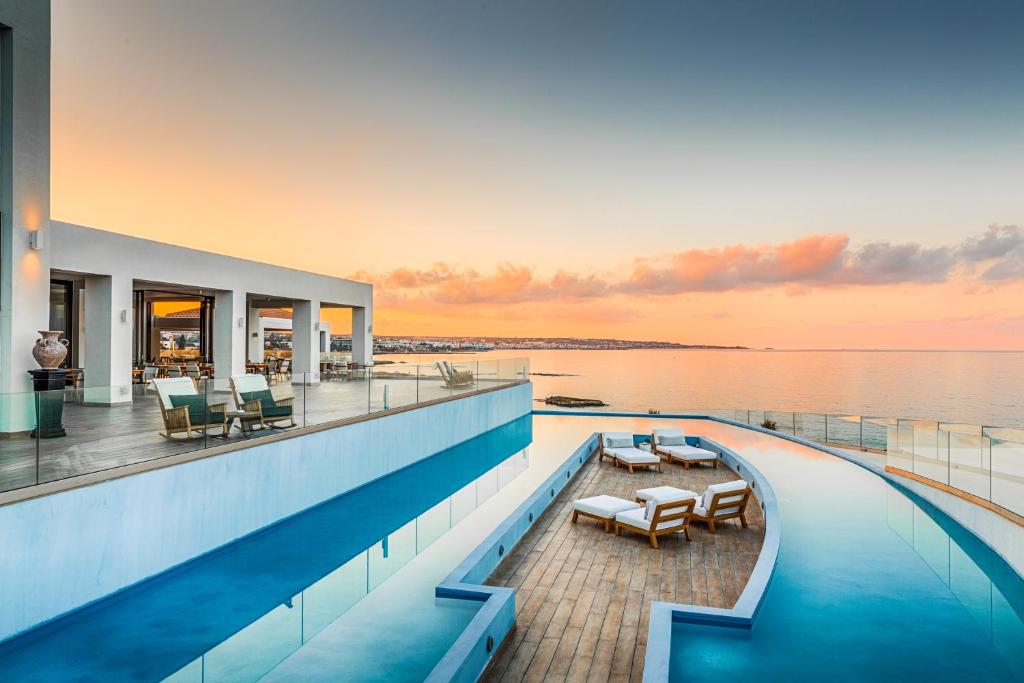 a house with a swimming pool on top of the water at Abaton Island Resort & Spa in Hersonissos