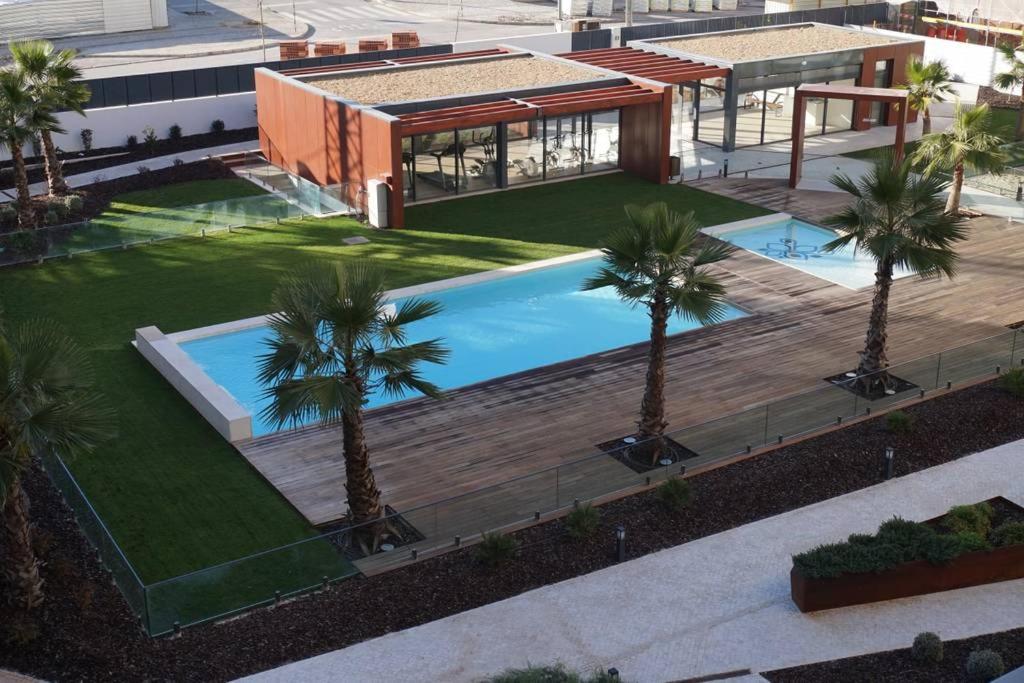 an overhead view of a building with a swimming pool and palm trees at Apartment with view on Lisbon Tage & swimming pool in Seixal